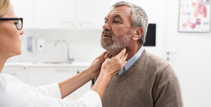 Female Doctor Doing Throat Examination On Older Man
