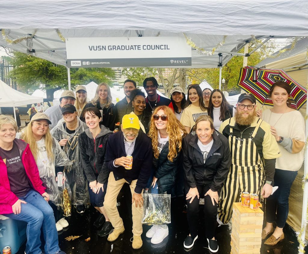 Group of people huddle under an awning during a tailgate party at Reunion