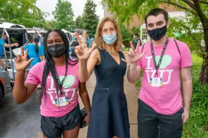 Provost Raver standing with students during move-in.