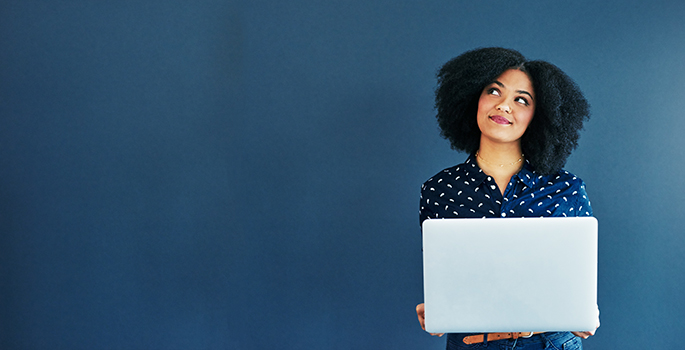A woman with her laptop looks upward, considering her options.