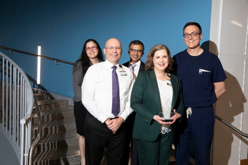 Molly Knostman, PharmD, MHA, (front) executive director of Inpatient Pharmacy Operations, was honored during the LHS Symposium. Behind her, from left, are Cheryl Gatto, PhD, PMP, Wesley Self, MD, MPH, Sunil Kripalani, MD, MSc, and Matthew Semler, MD, MSCI. (photo by Susan Urmy)