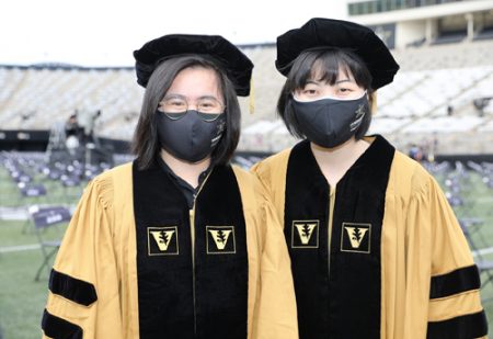 Ling Chen, who received her PhD in Biological Sciences, left, poses with Lei Su, who receigved her PhD in Hearing and Speech Sciences. 