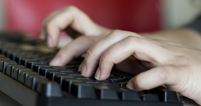 Person typing on a computer.
