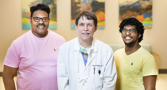 Jeremy Kerr, left, and his son Tyler, right, pose with Sam McKenna, MD, DDS, who performed corrective jaw surgery to repair their underbites and crossbites. 