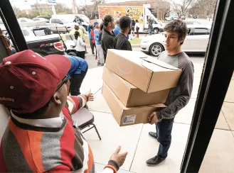 photo of students distributing supplies in neighborhood damaged by tornadoes