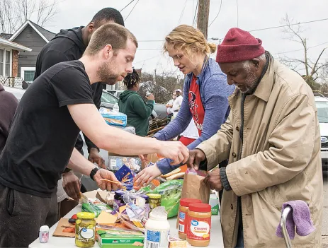 photo of students distributing supplies in neighborhood damaged by tornadoes