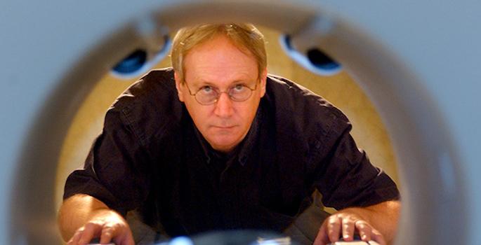 portrait of Gore peering through MRI tunnel