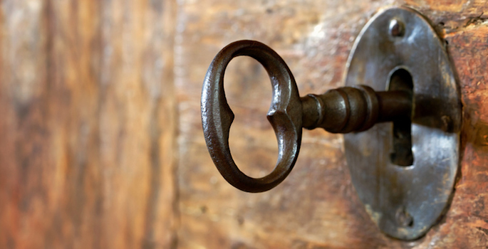 Closeup of an old keyhole with key on a wooden antique door