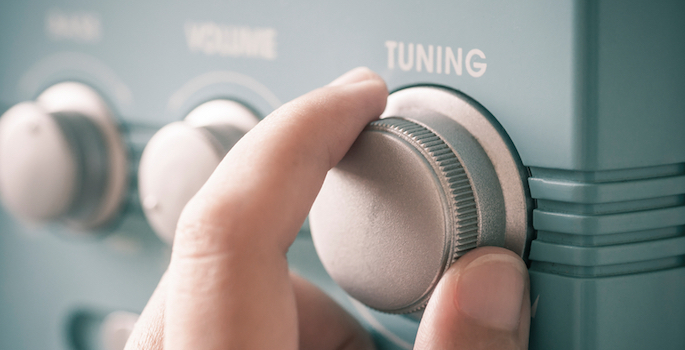 hand on radio tuning knob