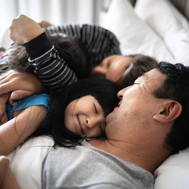 Family cuddling in bed