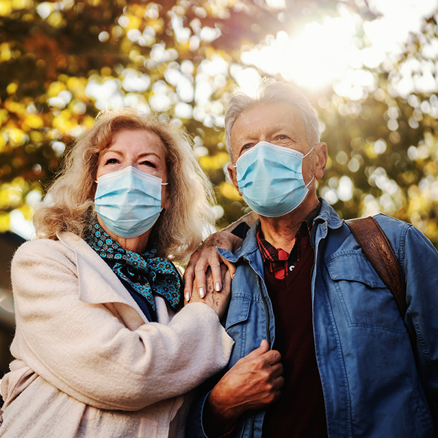 Senior couple embracing and wearing masks