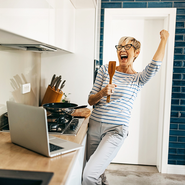 Woman singing in kitchen spoon