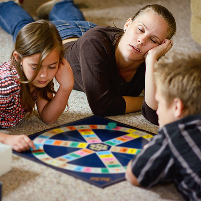 tired mother falling asleep playing with young children