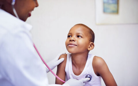 Black boy in white tank top at the doctor getting his heart checked