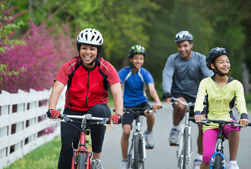 Family of four biking on a trail together in spring