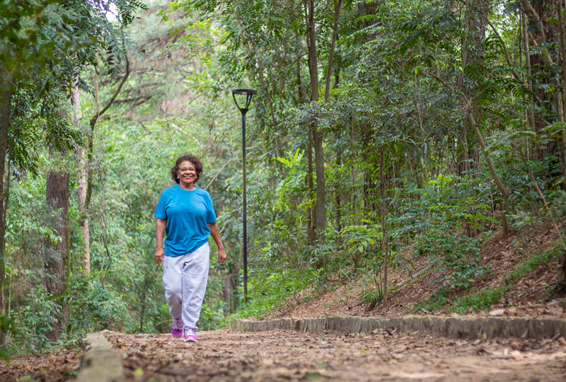 A woman walks alone along a path in the woods