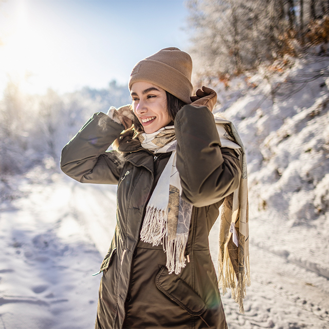 Woman taking a walk in the sun while it's snowy out