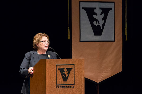 VUSN dean Linda Norman stands behind a wooden VU podium with the apricot VUSN banner beside her