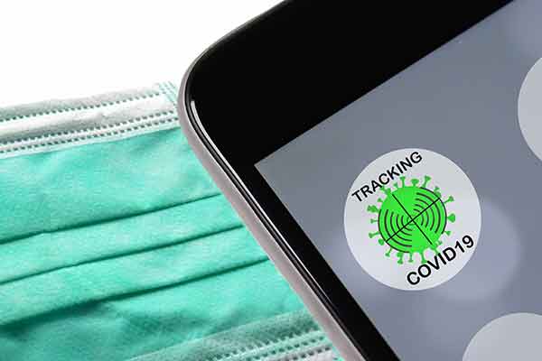 Cellphone showing app for contract tracing for COVID 19 next to a face mask