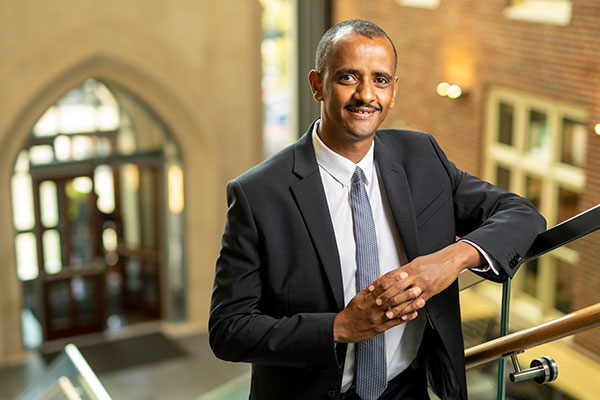 Vanderbilt research professor Mulubrhan Mogos standing on staircase in School of Nursing atrium