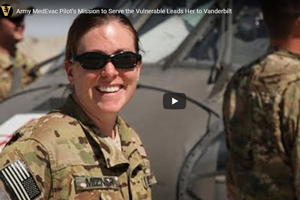 Female military pilot in fatigues smiling at camera