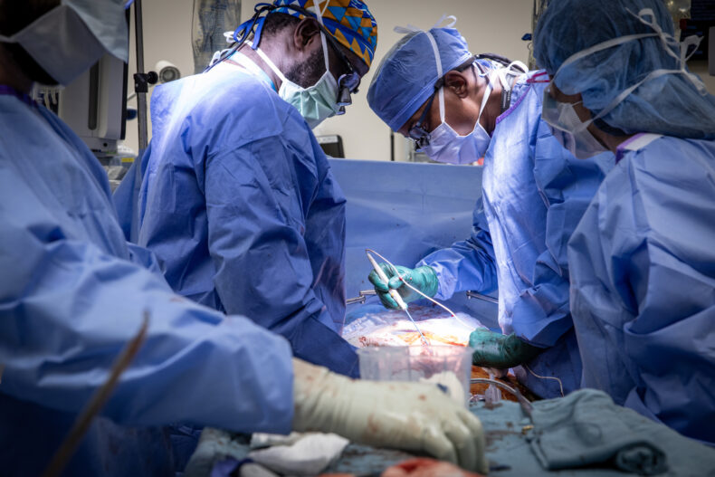 Enock Adjei, MD, left, and Wali Johnson, MD, perform a liver transplant in February 2024. (photo by Erin O. Smith)
