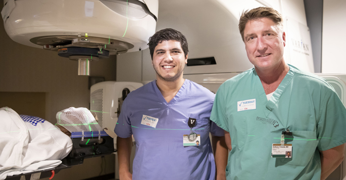 Mohamed Khattab, MD, left, and Anthony Cmelak, MD, are studying the use of a linear accelerator to target the areas in the brain’s limbic system that control the pathway for obsessive compulsive disorder. (photo taken prior to social distancing)