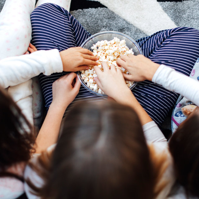 Kids eating popcorn during a sleepover.
