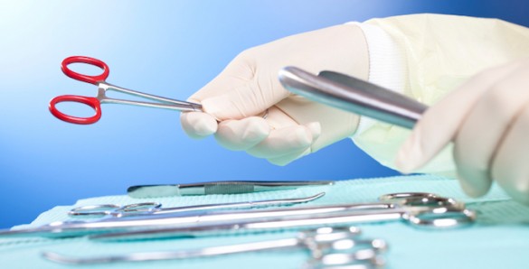 gloved hand handling sterile surgical tools