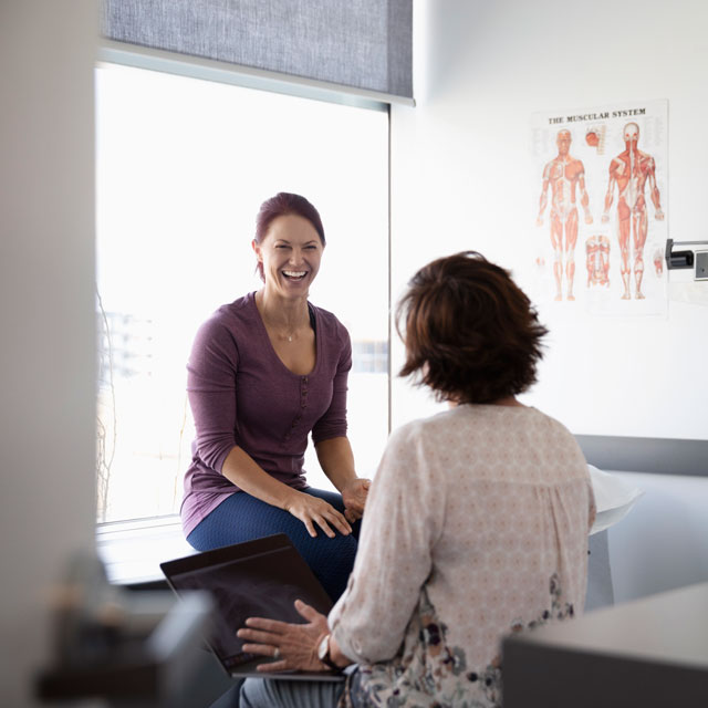 Woman laughs during a conversation with her midwife in a clinic