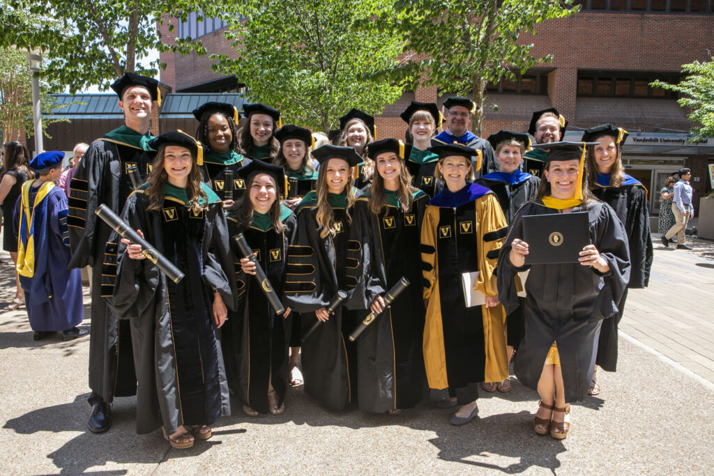 Several graduates and professors in regalia pose together