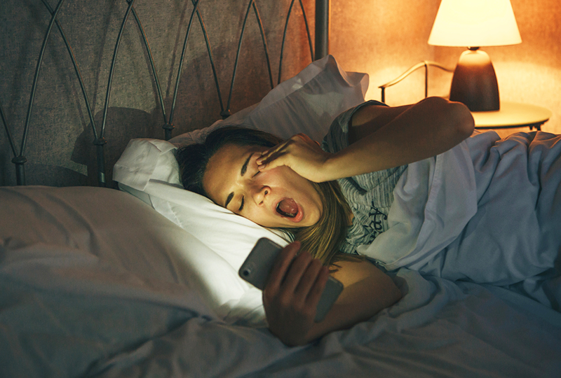 Woman in bed with phone