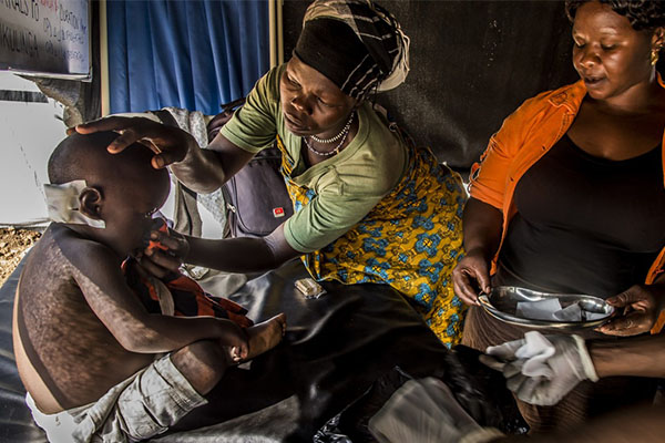 Aid workers with Sudanese refugee