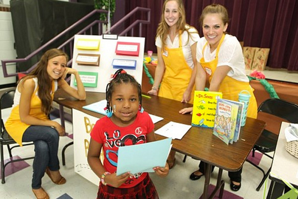 Rising kindergartener Jariah Hendricks finishes learning about healthy bedtime routines from VUSN students at the Kindergarten Kick-Off at Kirkpatrick Elementary School. Students pictured are, from left, Allie Morrison, Melanie Parker and Mallory Moore. (photo by Anne Rayner)