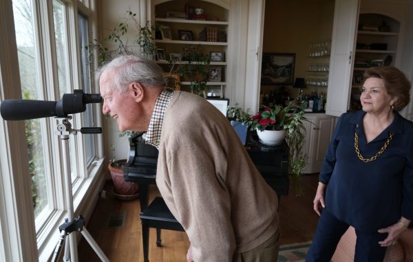 Jane Hughes Coble, BA’64, and Bill Coble, BE’54, aim a mounted telescope at a dark bundle of sticks atop a sycamore tree across the river. 