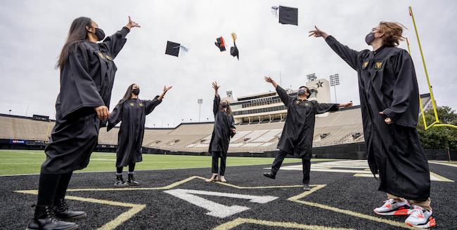 Commencement graduates throwing their mortar boards
