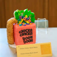 A cake baked to look like a worm crawling up the side of the book to eat a piece of lettuce filled with letters.