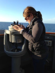 Susan using an astrolabe on deck of a ship at sea
