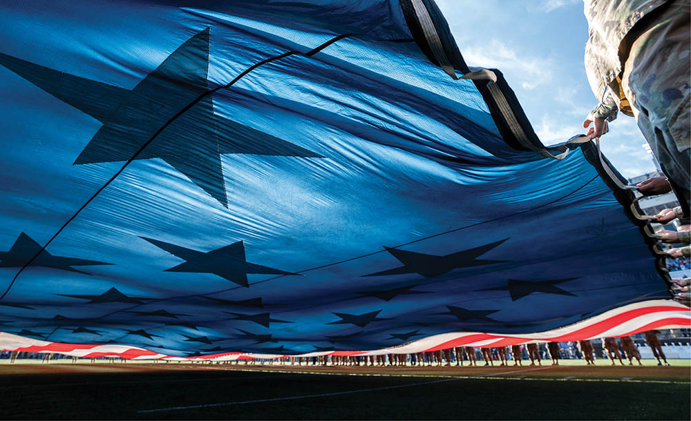 Close-up photo of giant U.S. flag being unfurled on the football field