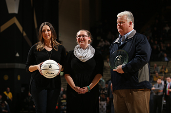 Sarah Sturgeon, center, accepts the award for last year's Vanderbilt Basketball Sustainability Competition on behalf of Maulik Patel’s Lab by Chelsea Hamilton of SEMO and Robert Cheney of Waste Management. (John Russell/Vanderbilt University)