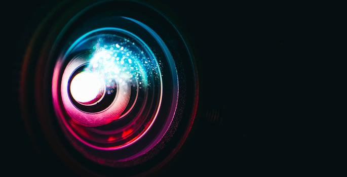 close-up of film projector lens glowing as if light is passing through it