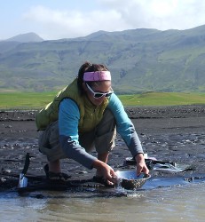 Tamara Carley kneeling by a stream