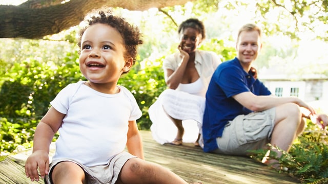 baby sitting outside with parents