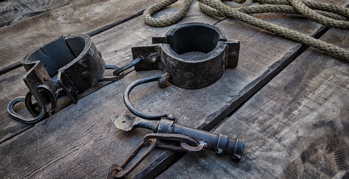 close-up of iron shackles lying on the deck of a ship