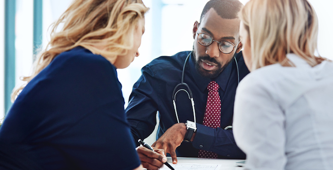 african american doctor consulting with two women in office