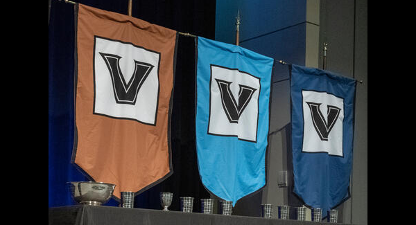 faculty awards on a table with V banners behind them