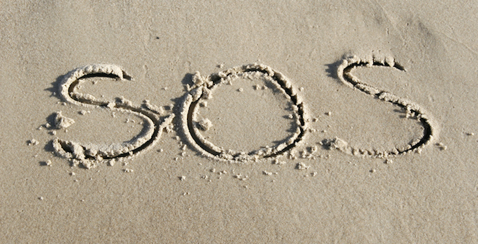 SOS written in sand on beach