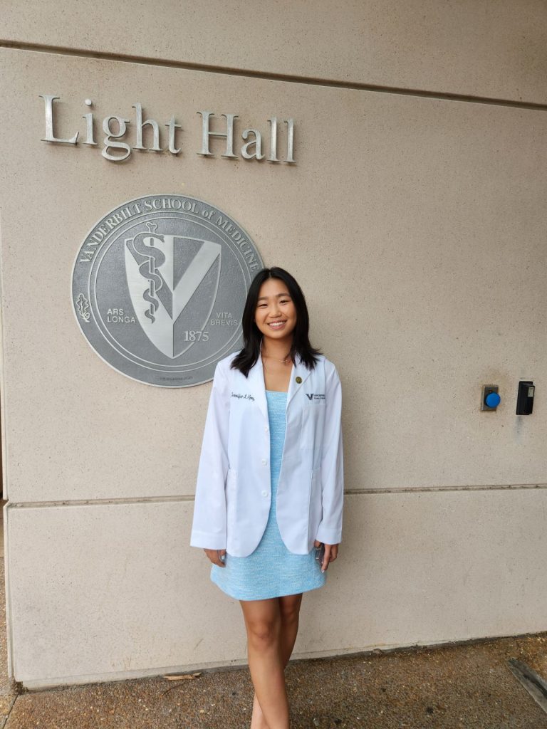 Jenn Kong poses in white coat.