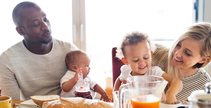 African American dad and Caucasian mom enjoying breakfast with their super adorable kids