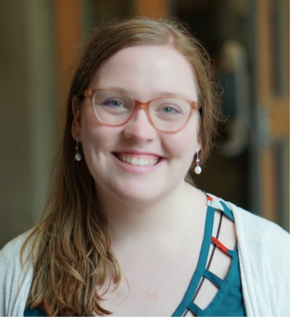 Brewer, shown from the shoulders up, smiles at the camera.